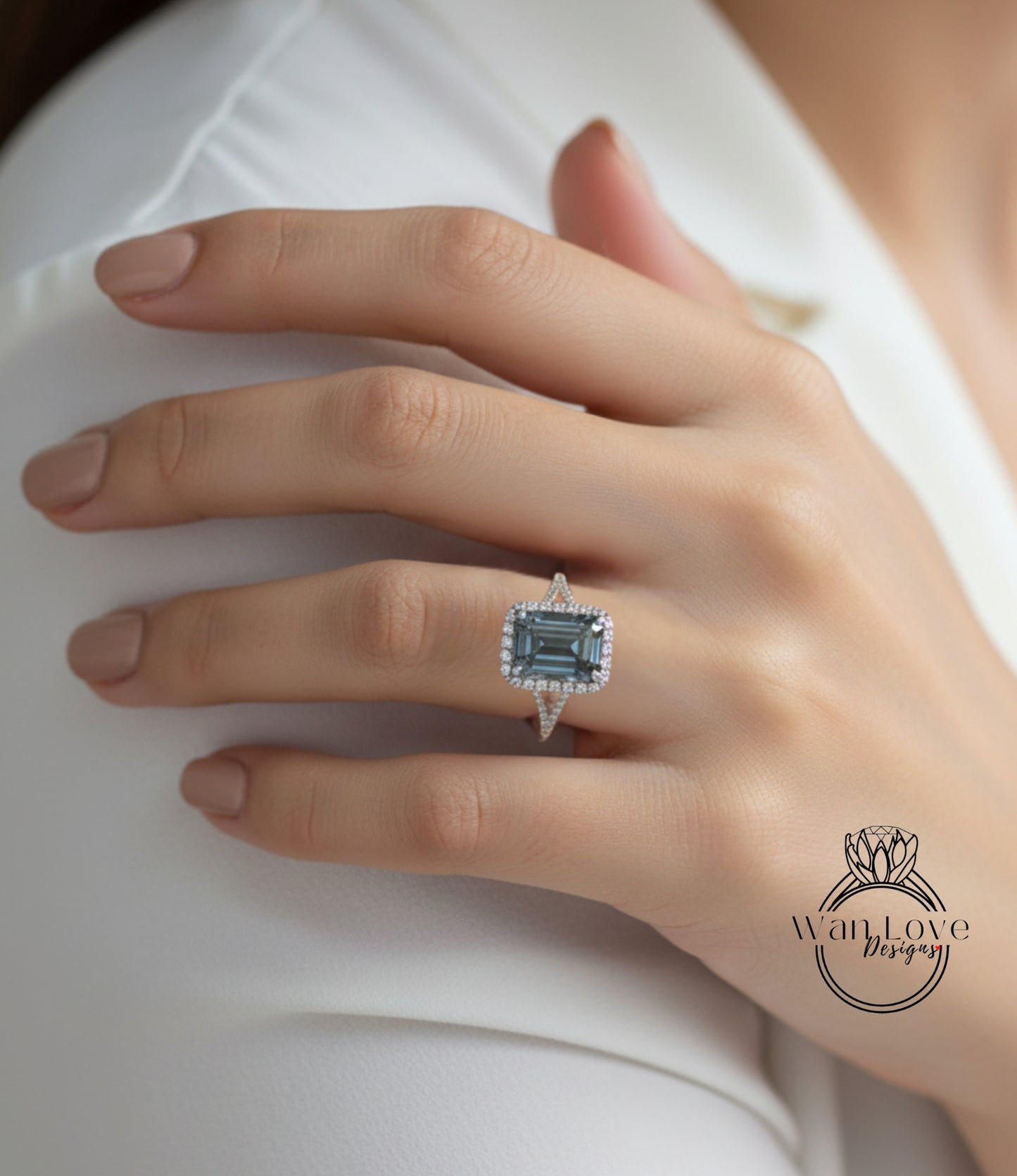 A close-up of a person's hand wearing a large, blue gemstone ring with a halo around it.