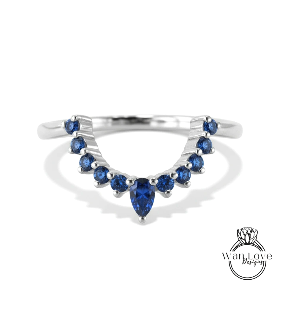 A silver ring with a large blue gemstone at the center, surrounded by smaller blue gemstones.