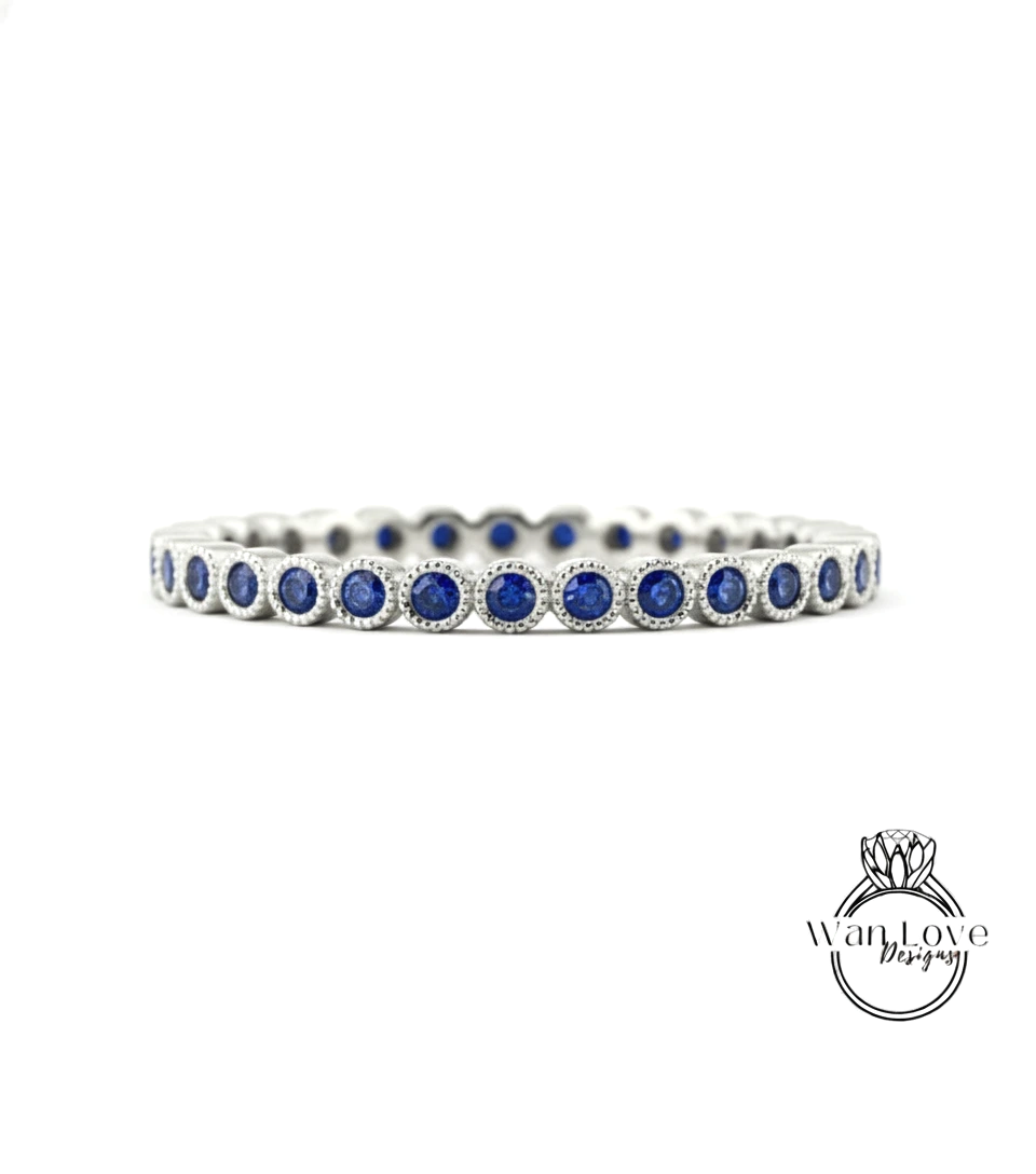 A silver band adorned with blue sapphires, showcasing a row of round gemstones set in a metallic frame.