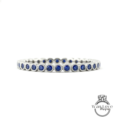 A silver band adorned with blue sapphires, showcasing a row of round gemstones set in a metallic frame.
