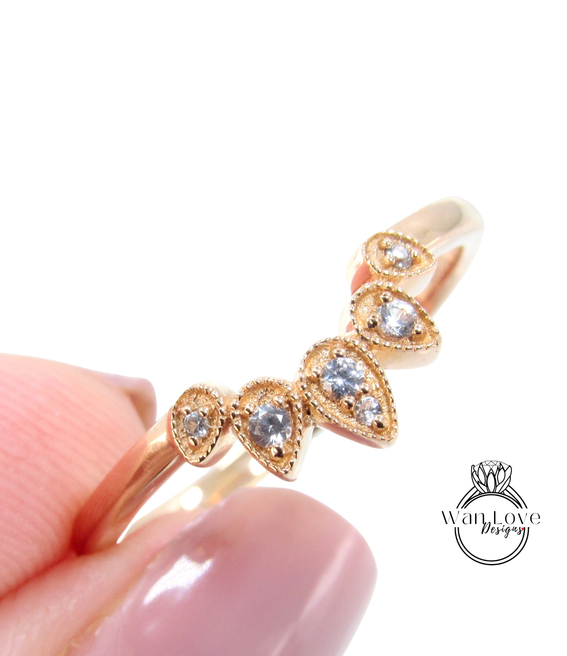 A close-up image of a gold ring with a decorative design featuring small diamonds.