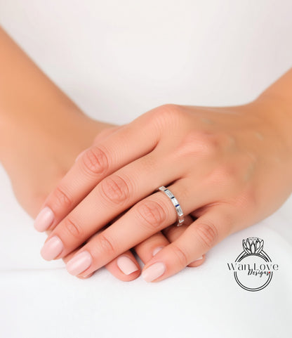 A close-up image of a person's hands wearing a silver ring on the ring finger.