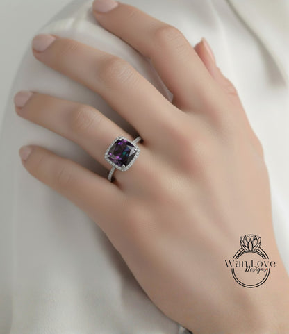 A close-up of a hand wearing a ring with a large purple gemstone.
