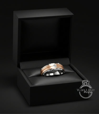 A gold and silver wedding ring is displayed in a black jewelry box against a dark background.