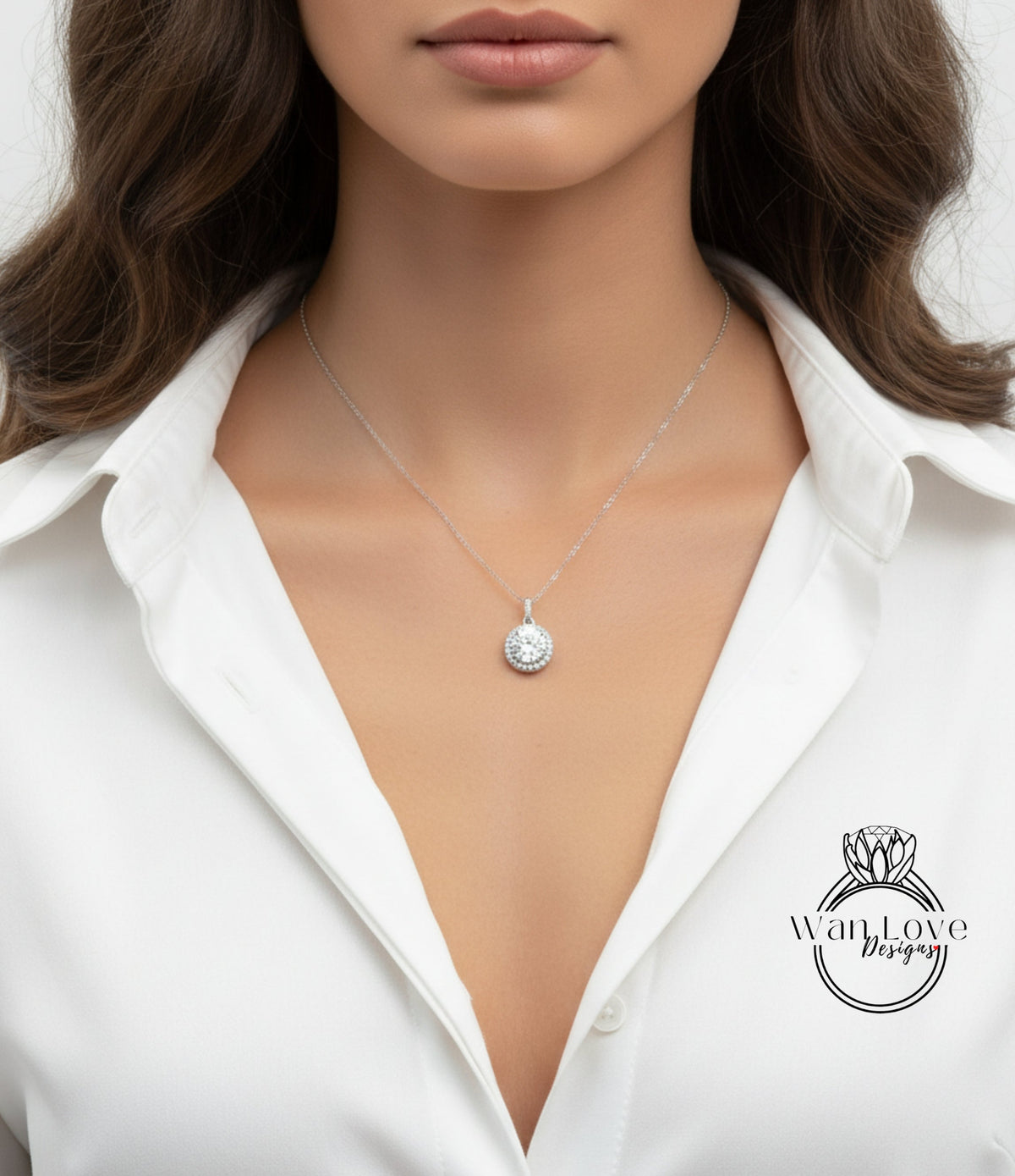 A close-up of a woman wearing a white shirt and a necklace with a pendant.
