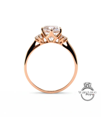 A gold ring with a large central diamond and three smaller diamonds on either side.
