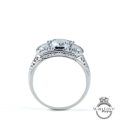 A silver ring with a large central diamond surrounded by smaller diamonds, showcasing intricate metalwork and detailing.