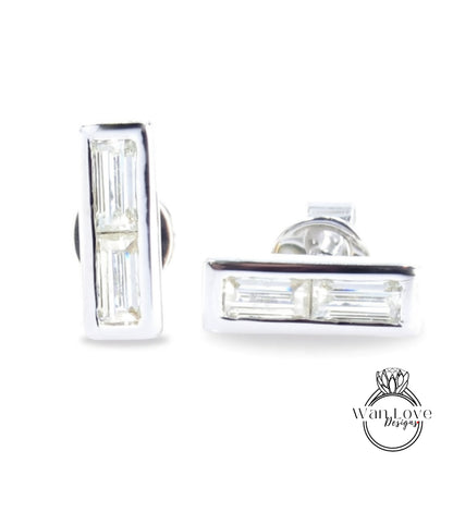 A pair of silver earrings with rectangular-shaped cut gemstones.
