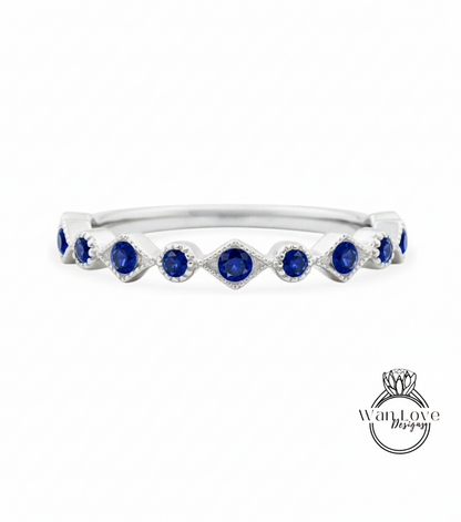 A silver ring with a row of blue sapphire stones set in a diamond pattern.