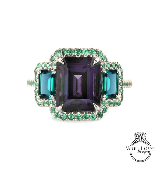 A ring with a large purple gemstone surrounded by smaller green gemstones, set in a silver band.