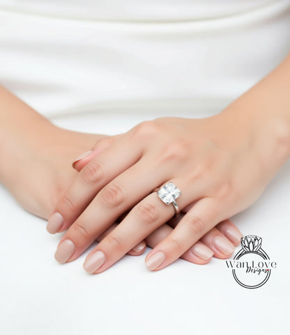 A close-up of a person's hands wearing a large diamond engagement ring.