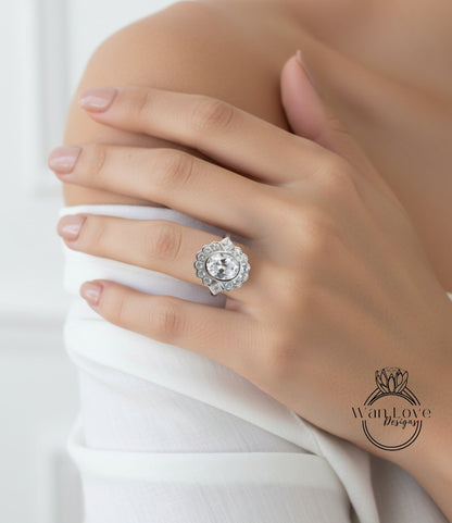 A close-up of a person's hand wearing a large, ornate diamond ring on the ring finger.