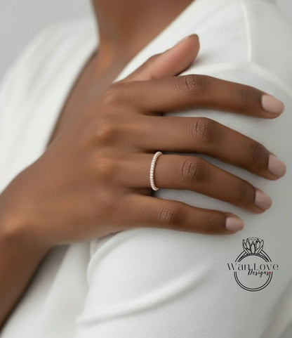A close-up of a person's hand wearing a delicate gold ring on the ring finger.
