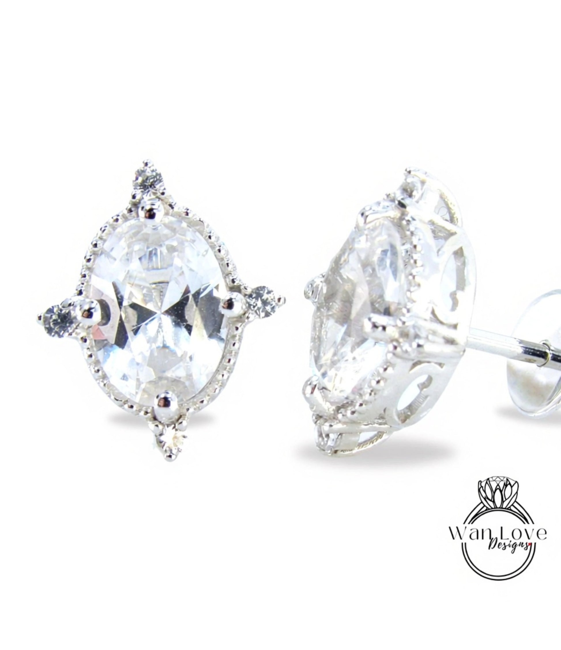 A pair of elegant earrings with a large, clear gemstone set in a decorative metal frame.