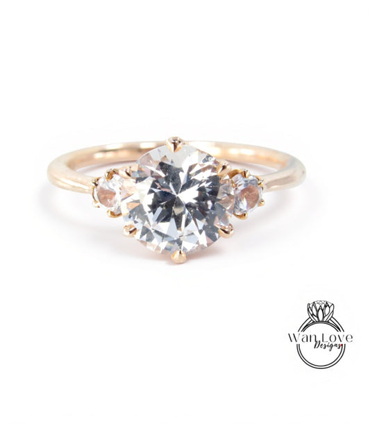 A gold ring with a large, clear gemstone set in the center, surrounded by smaller gemstones.