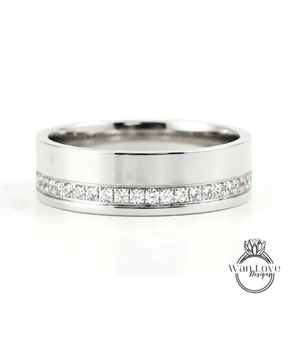 A silver-colored wedding band with a row of diamonds set along the inside of the band.