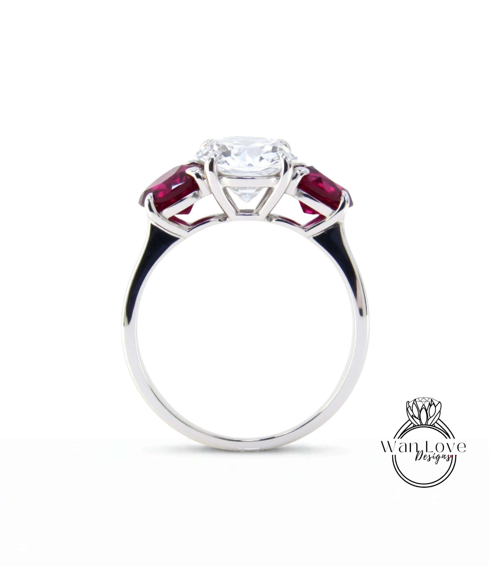 A silver engagement ring with a large central diamond surrounded by two smaller diamonds on either side, set in a silver band with a red gemstone.