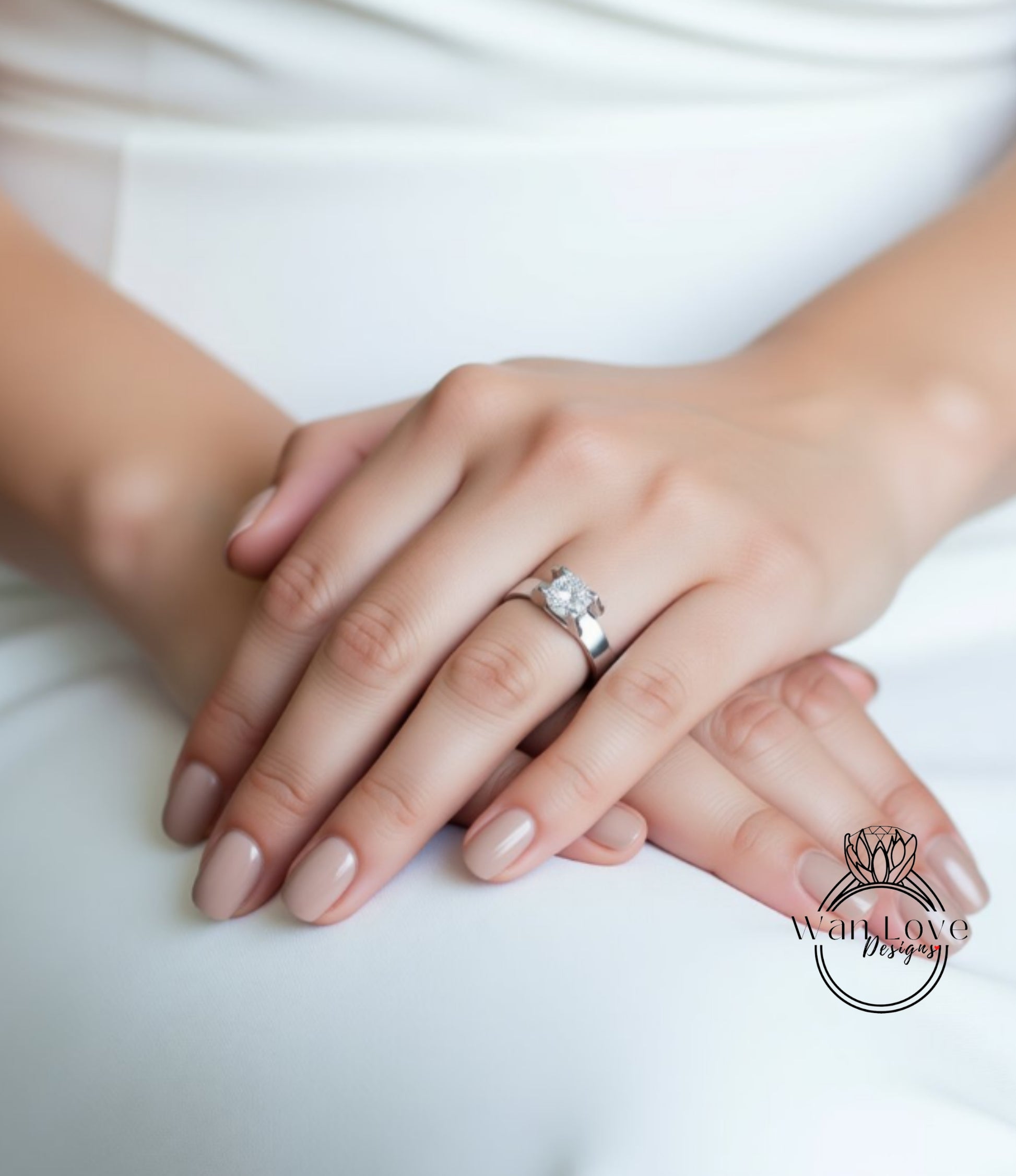 A close-up image of a person's hands wearing a silver ring with a large diamond.