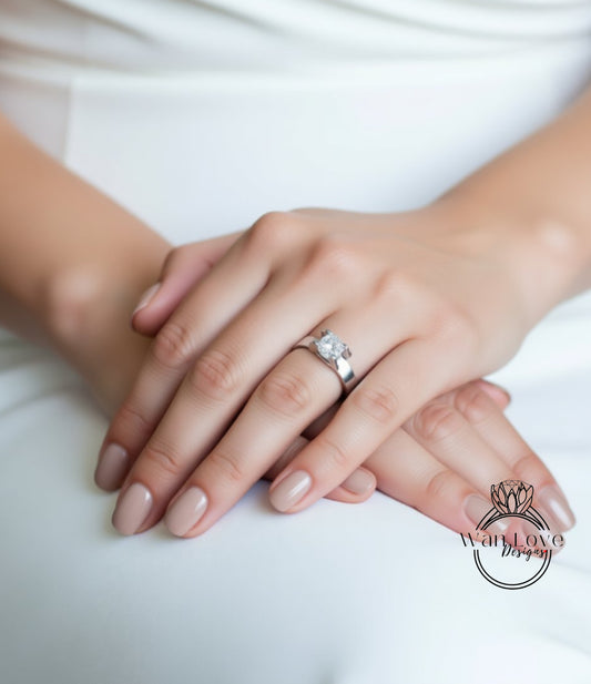 A close-up image of a person's hands wearing a silver ring with a large diamond.