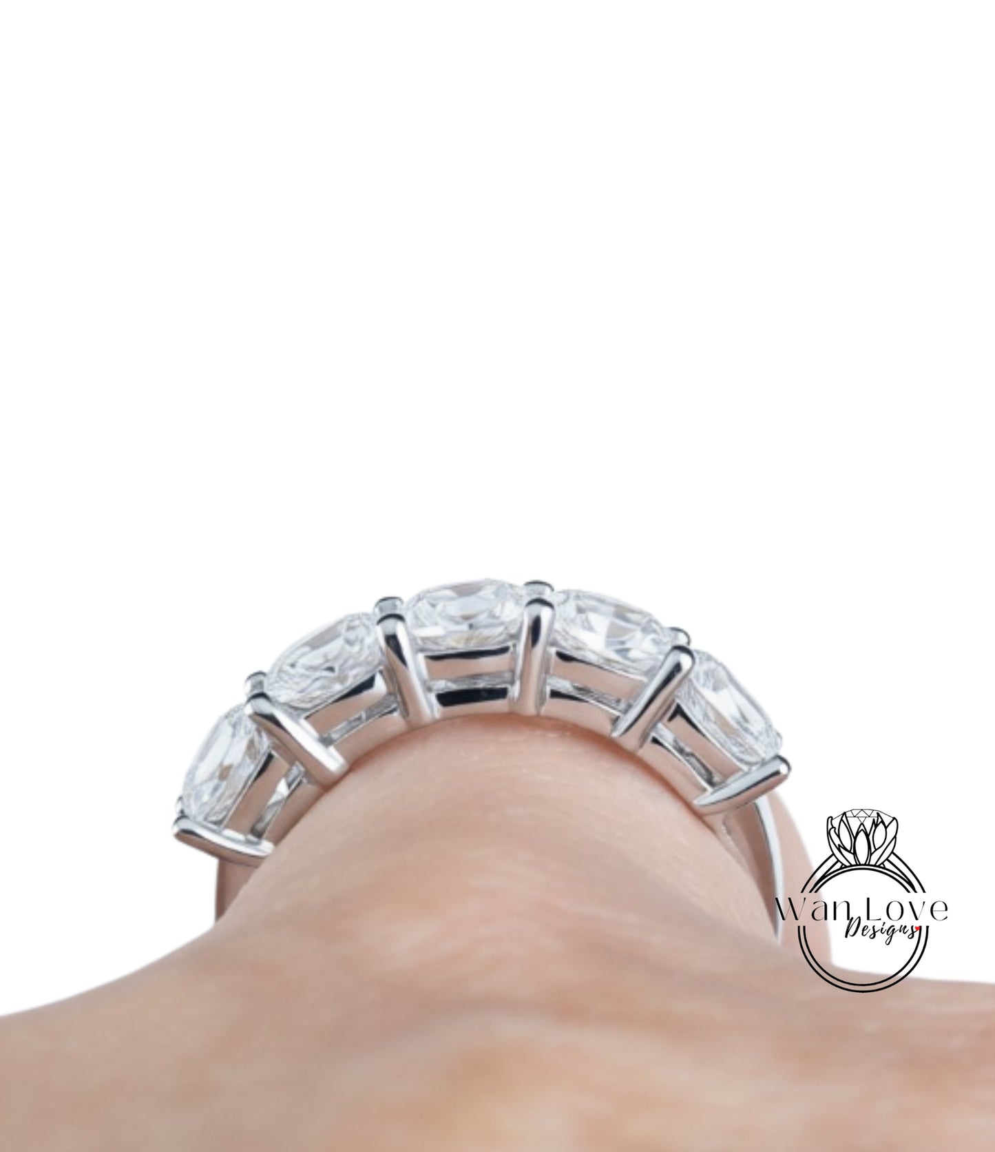 A close-up view of a person's hand wearing a large, ornate ring with multiple clear gemstones.