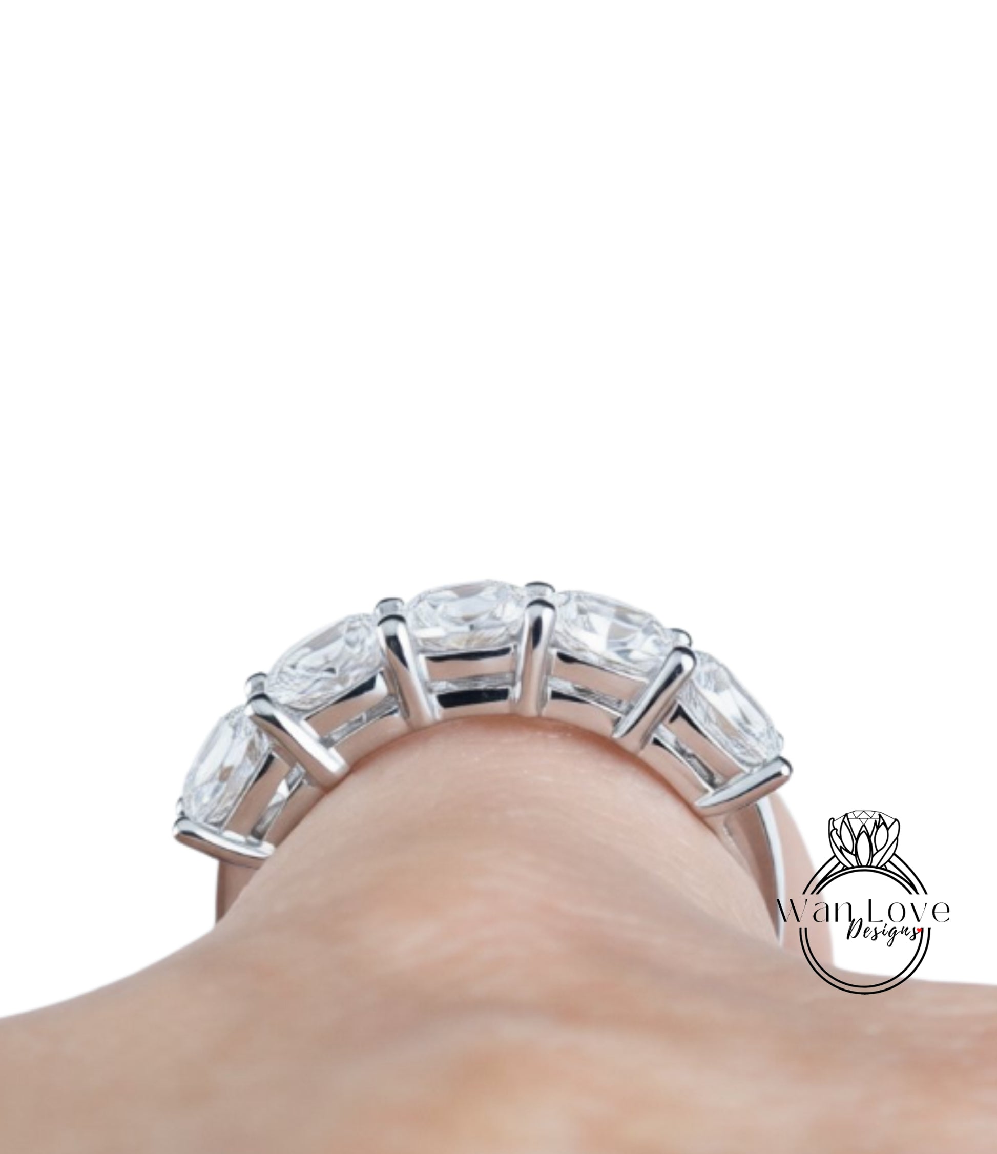 A close-up view of a person's hand wearing a large, ornate ring with multiple clear gemstones.