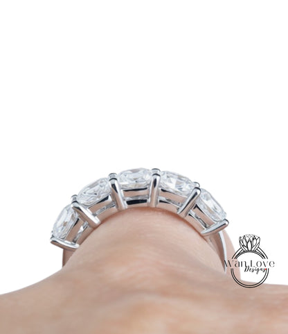 A close-up view of a person's hand wearing a large, ornate ring with multiple clear gemstones.