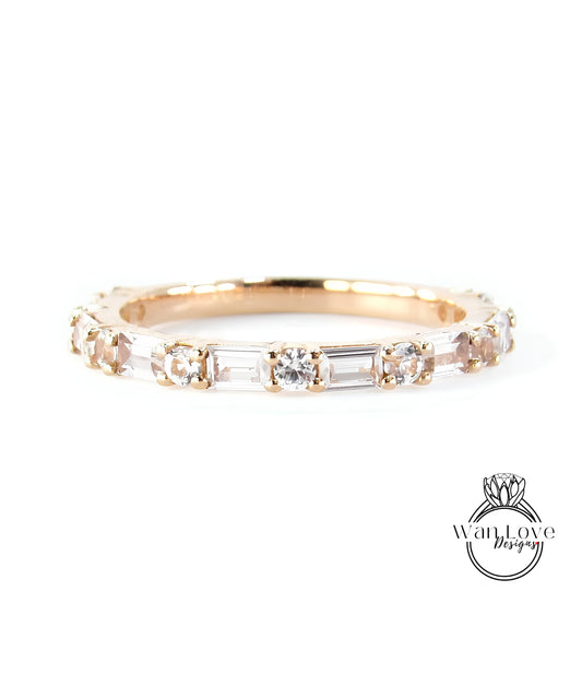 A gold band ring with a row of clear gemstones, including diamonds, set in a thin gold band.