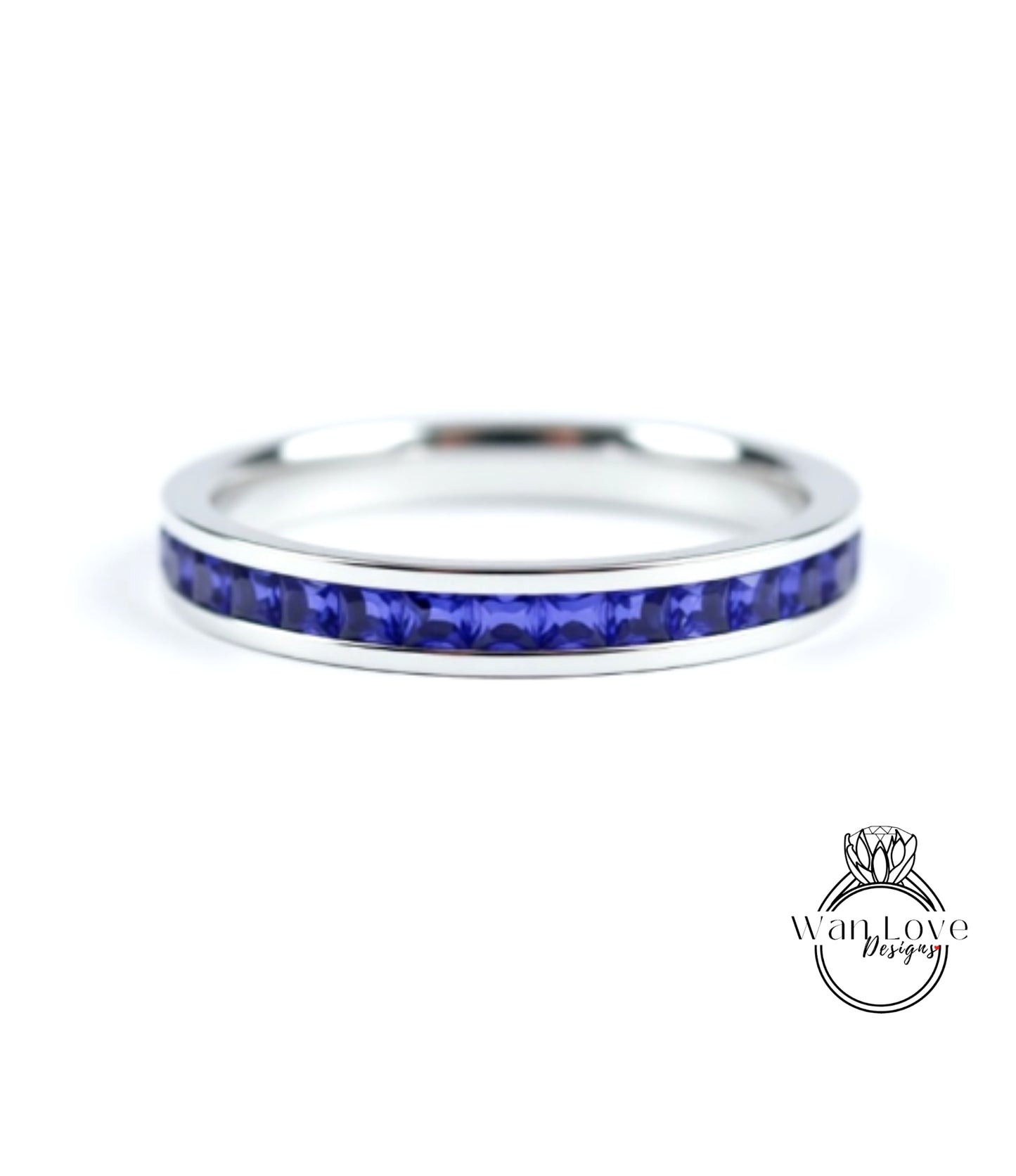 A silver ring with a row of blue sapphire gemstones set in the band.