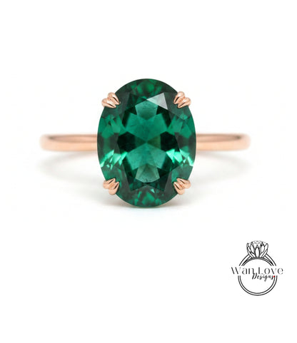 a large oval-shaped green gemstone set in a rose gold ring.