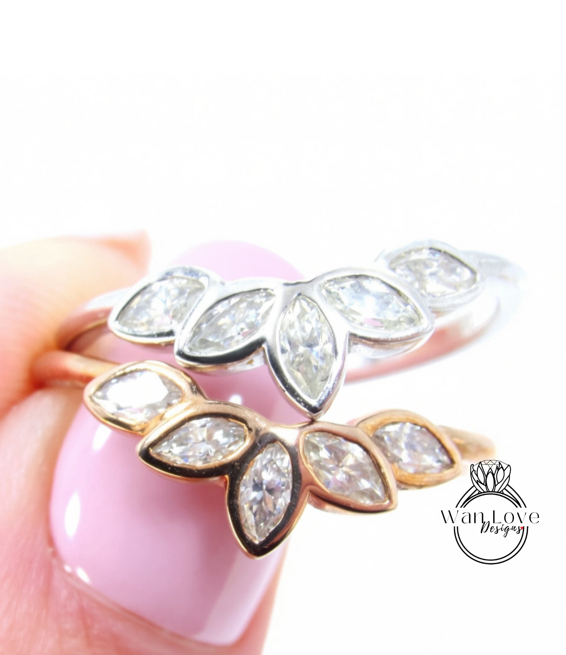 A close-up of a person's hand holding a ring with a floral design, featuring multiple diamond-encrusted leaves.