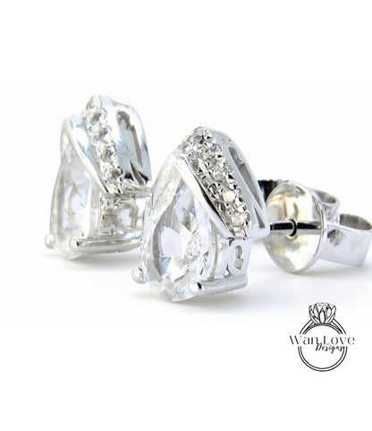 A pair of elegant silver earrings with large, clear gemstones set in a decorative metal frame.