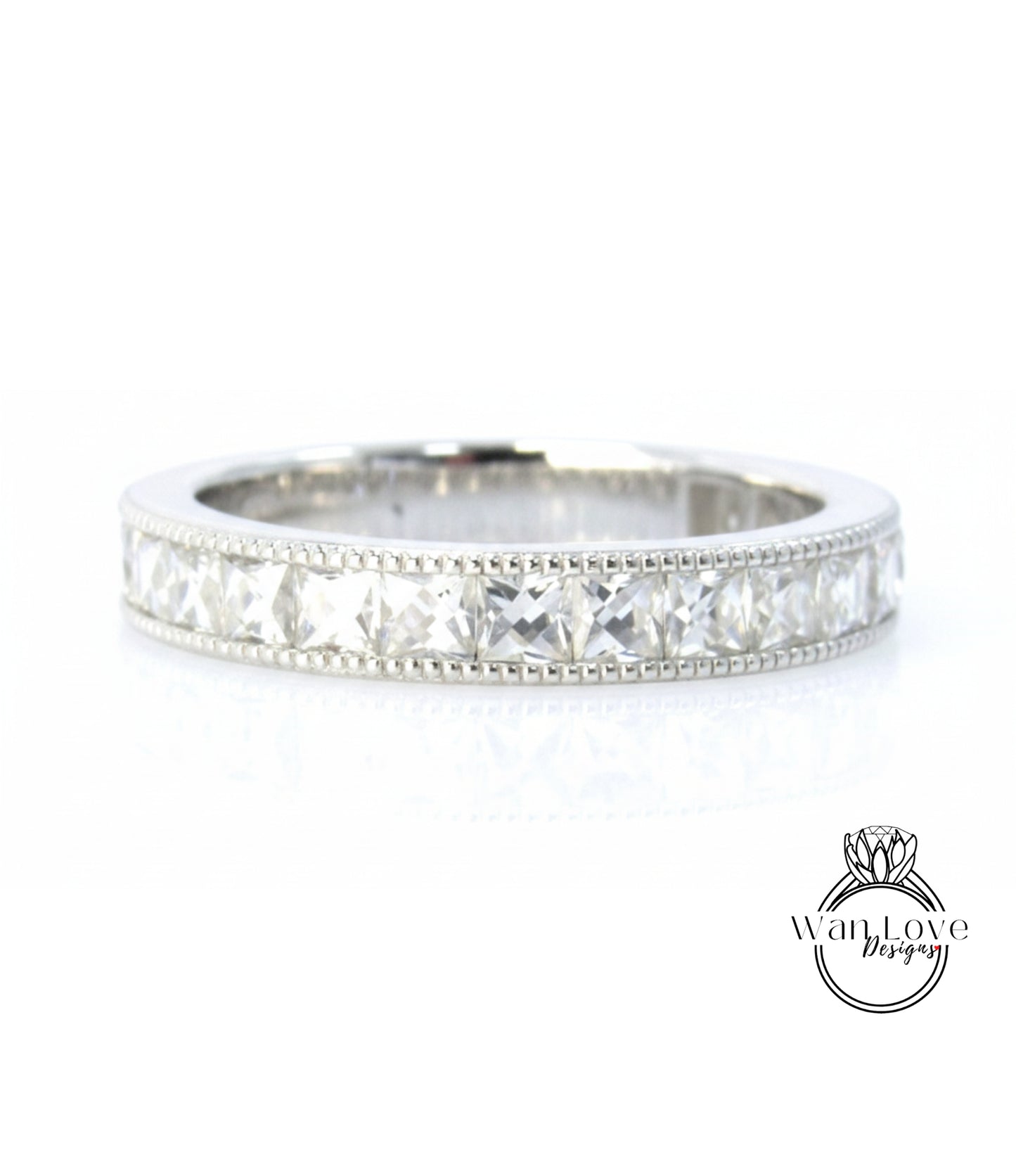 A silver band ring with a row of clear gemstones, likely diamonds, set in a decorative pattern.