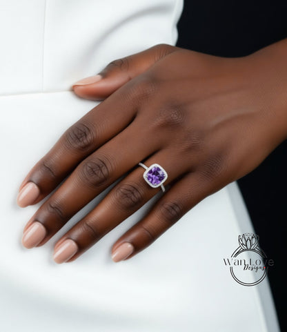 A close-up of a hand wearing a ring with a purple gemstone.