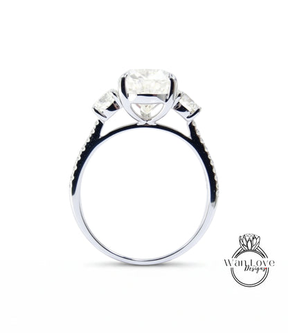 A silver engagement ring with a large central diamond and three smaller diamonds on either side.
