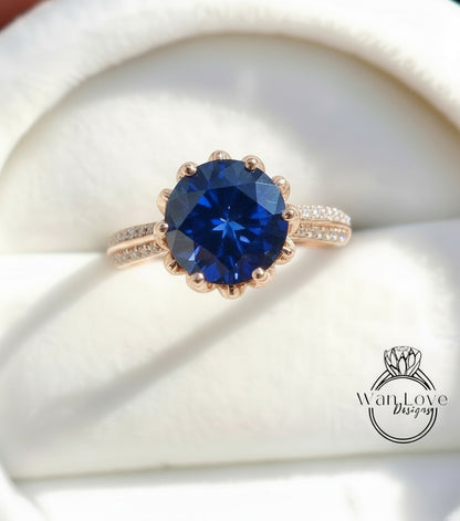 A close-up image of a gold ring with a large blue gemstone, placed on a white background.