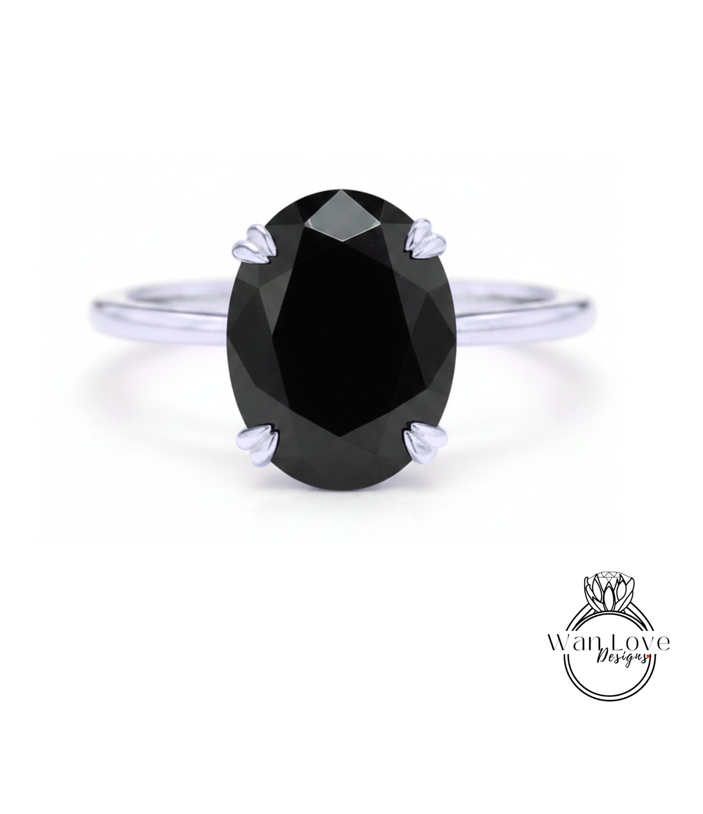 A close-up of a silver ring with a large, dark black diamond as the centerpiece.