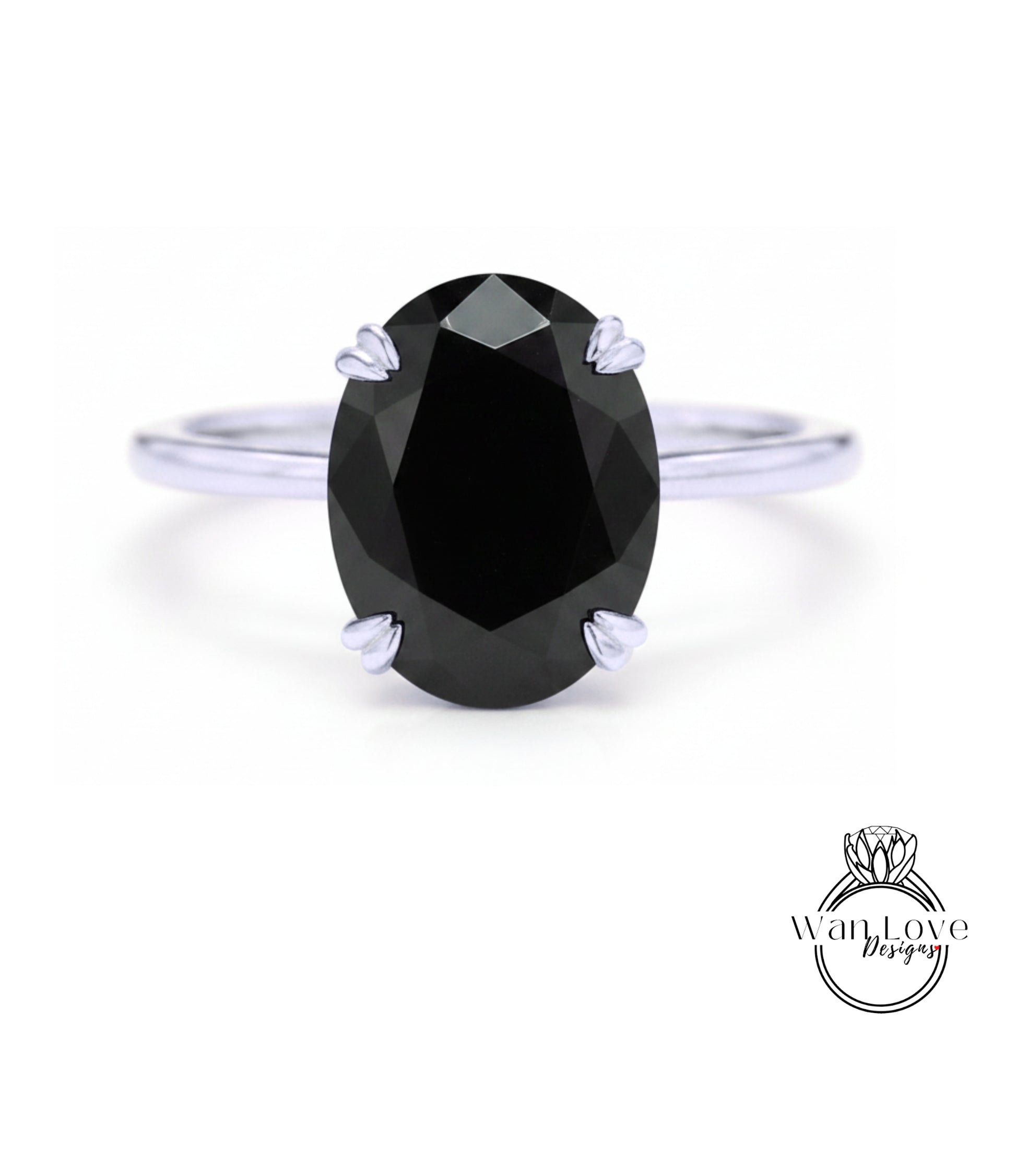 A close-up of a silver ring with a large, dark black diamond as the centerpiece.