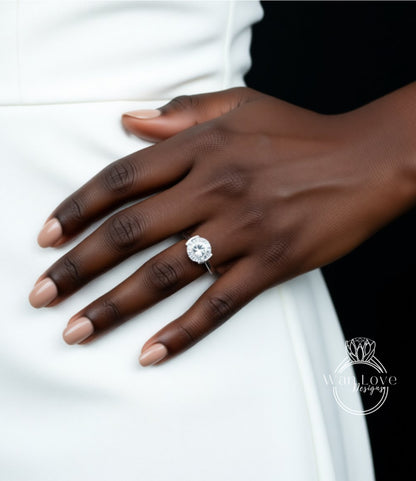 A close-up of a hand wearing a large diamond engagement ring.