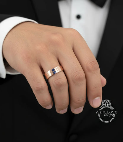 A close-up of a person's hand wearing a gold ring with a blue gemstone.