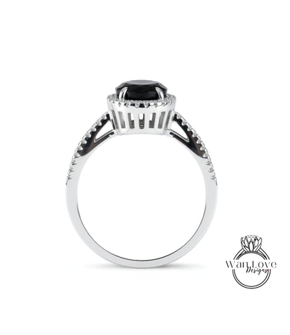 A silver ring with a large black gemstone, possibly a diamond, at the center.