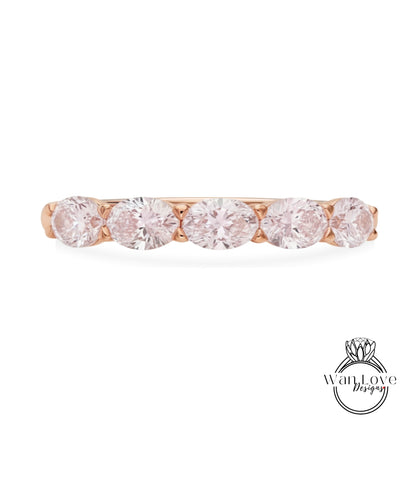 A rose gold ring with a row of five round diamonds set in the band.