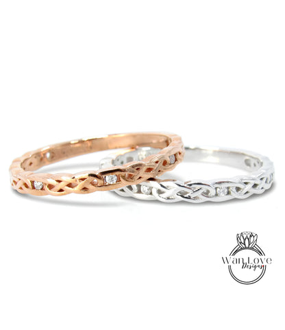 Two rings with intricate designs, one in gold and the other in silver, are displayed against a white background.