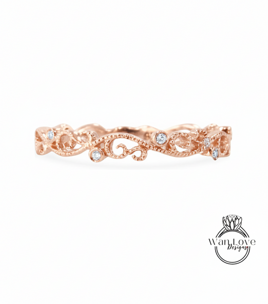 a rose gold ring with a delicate floral design and small diamonds set in it.