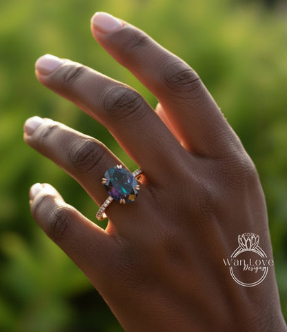 A close-up of a hand wearing a ring with a large, colorful gemstone.