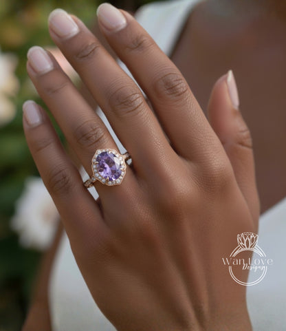 A close-up of a person's hand wearing a gold ring with a large purple gemstone.