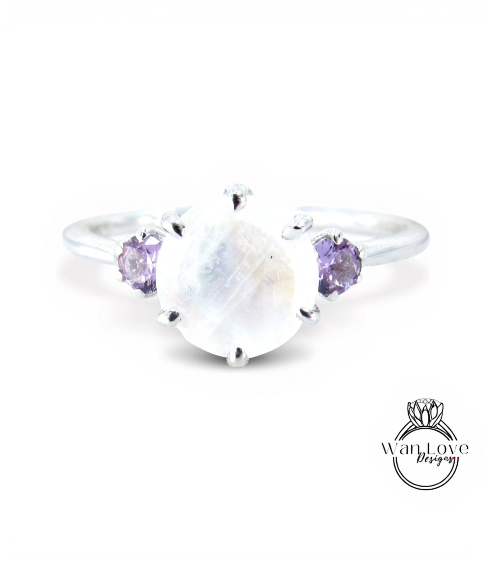 A silver ring with a large moonstone and two purple gemstones on either side.
