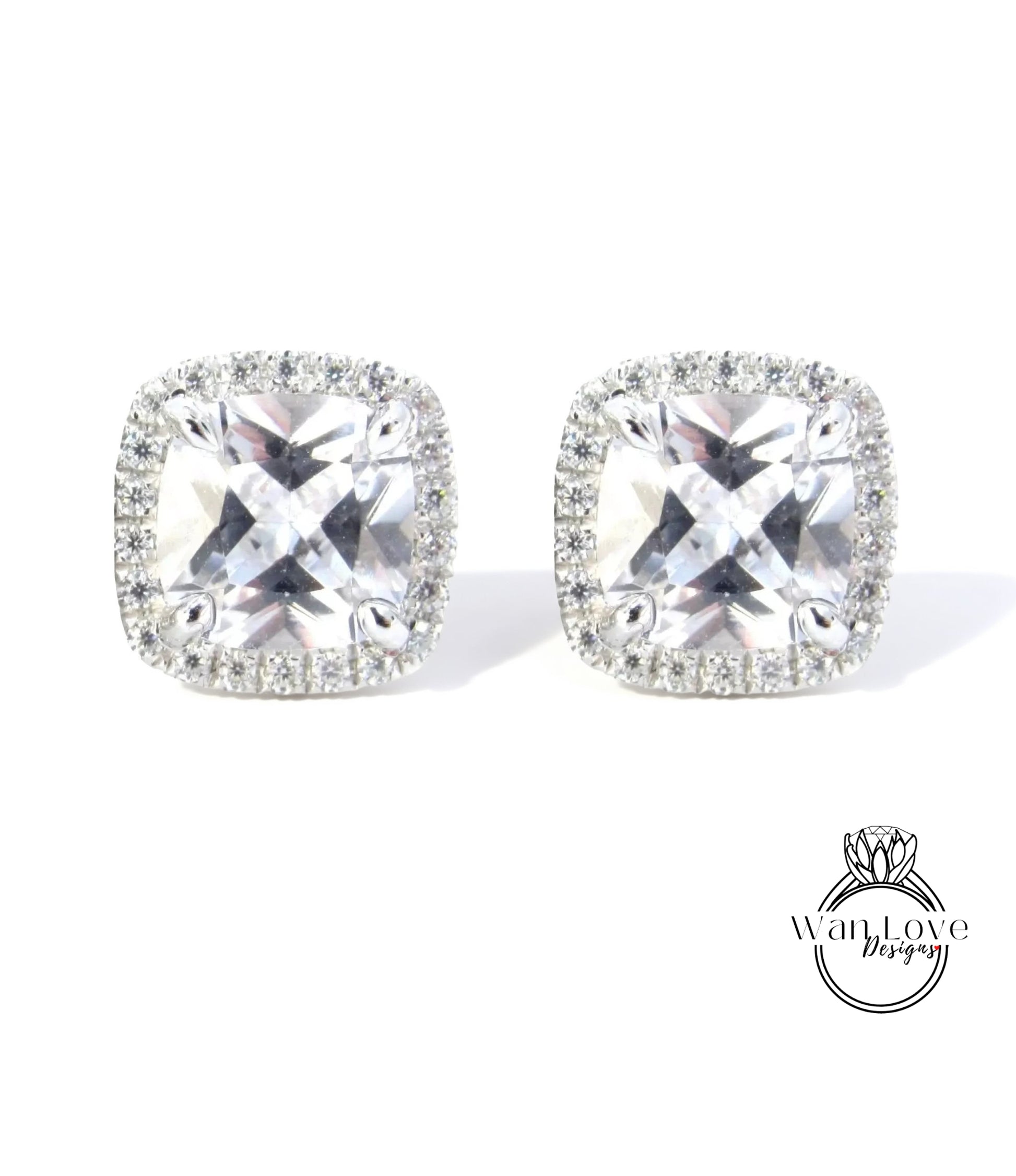 A pair of elegant earrings with large, clear gemstones set in a halo of smaller diamonds.