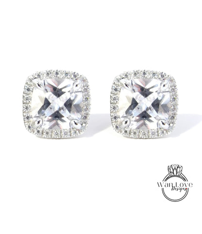 A pair of elegant earrings with large, clear gemstones set in a halo of smaller diamonds.