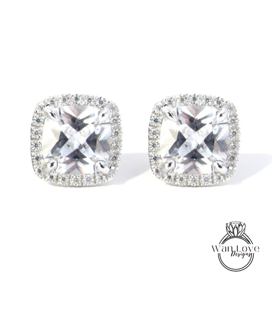 A pair of elegant earrings with large, clear gemstones set in a halo of smaller diamonds.