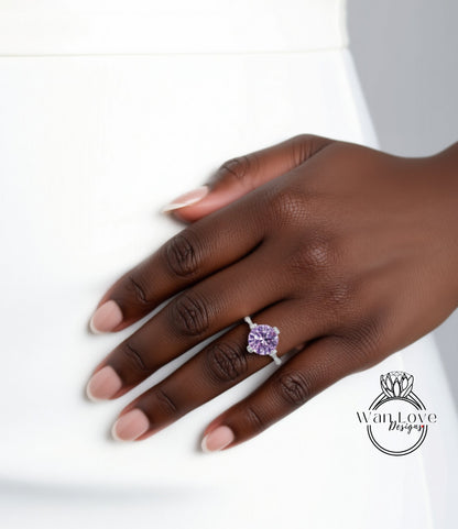 A close-up of a hand wearing a ring with a large purple gemstone.